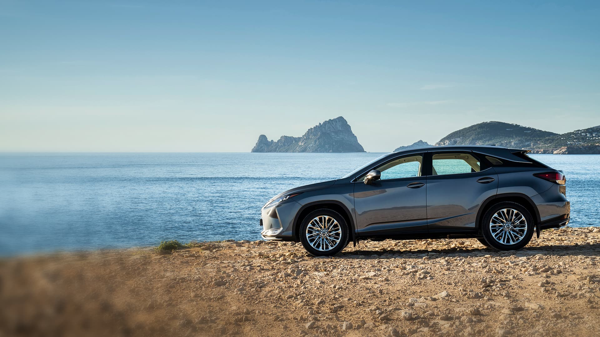 Lexus RX en azul oscuro conduciendo por la ciudad.